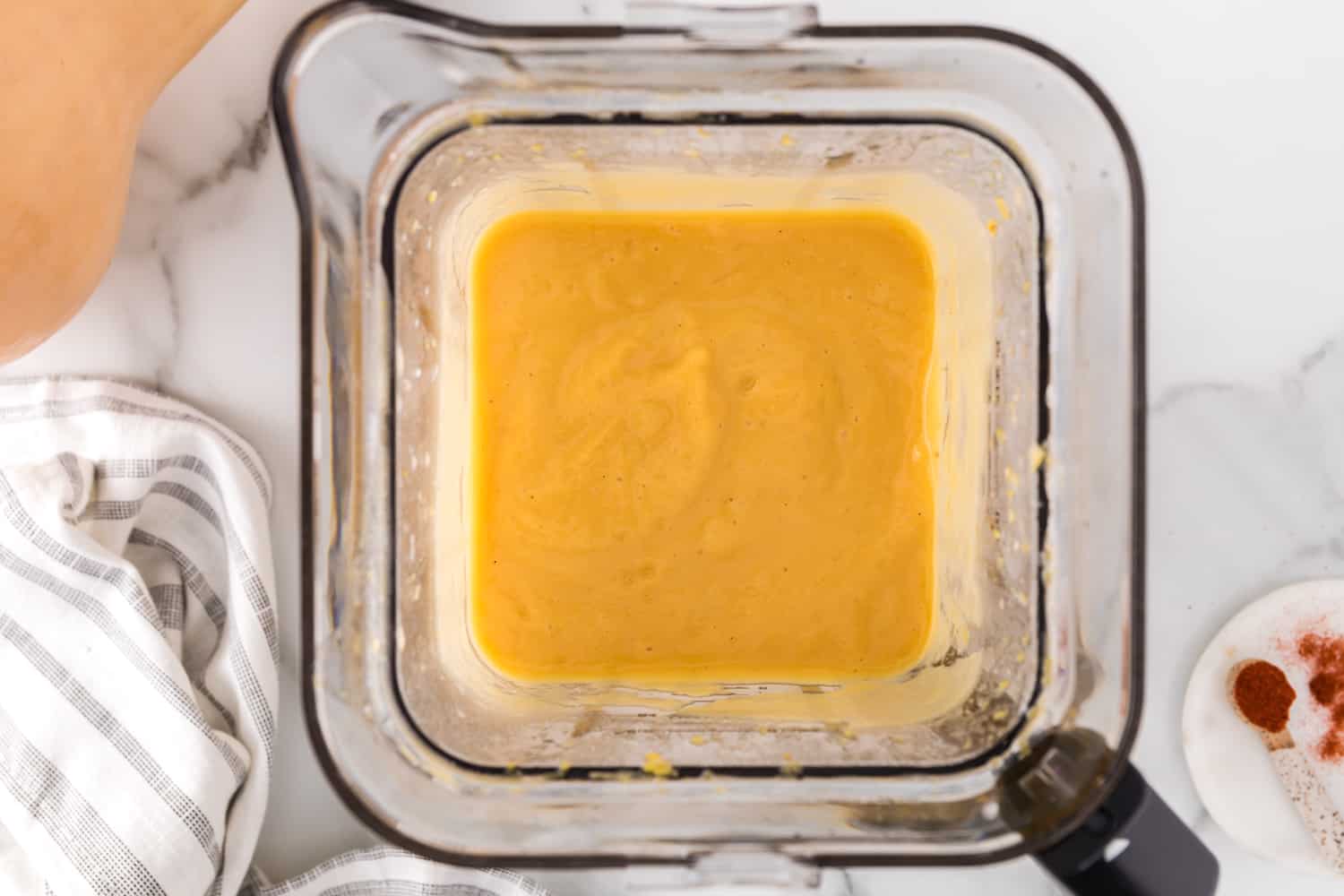 Smooth butternut squash soup in a blender.