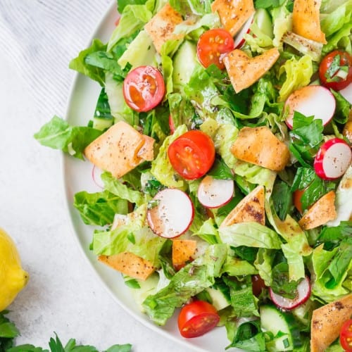 Square image of fattoush salad with crispy pita pieces on top.