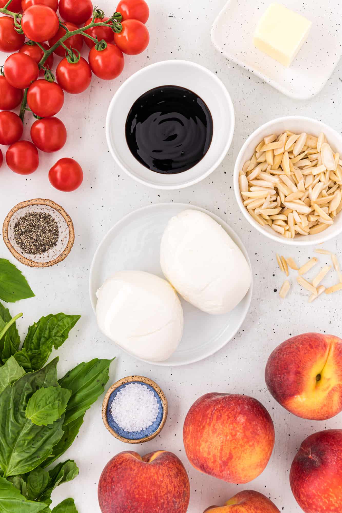 Ingredients needed for recipe, including fresh peaches, basil, burrata.