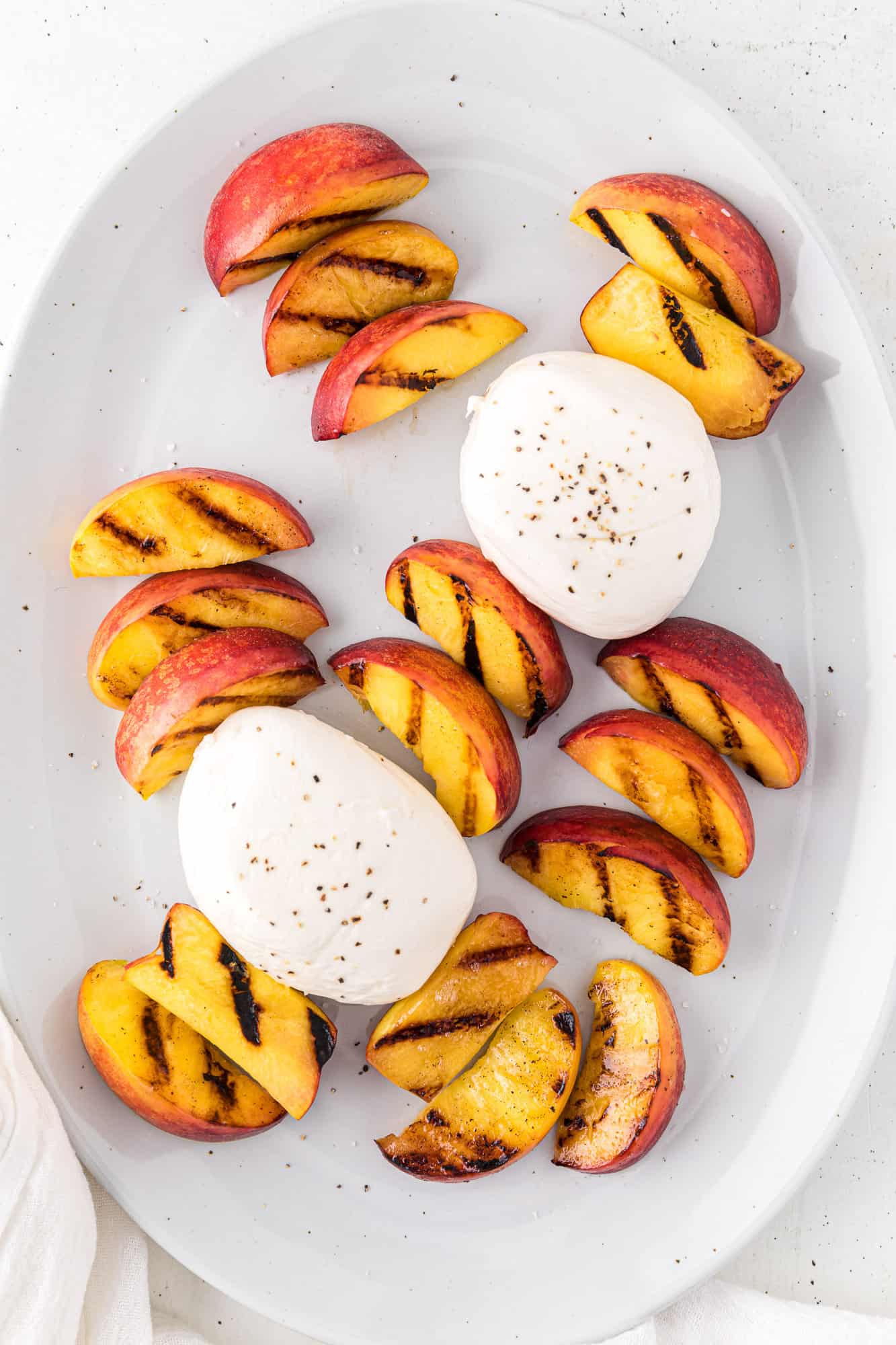 Grilled peaches on platter with burrata cheese.