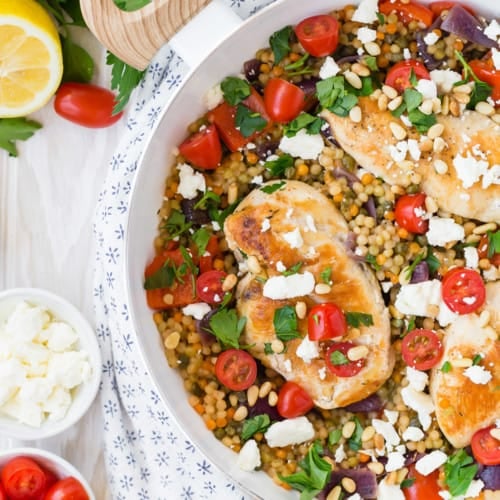 One pan chicken and couscous in a white skillet.