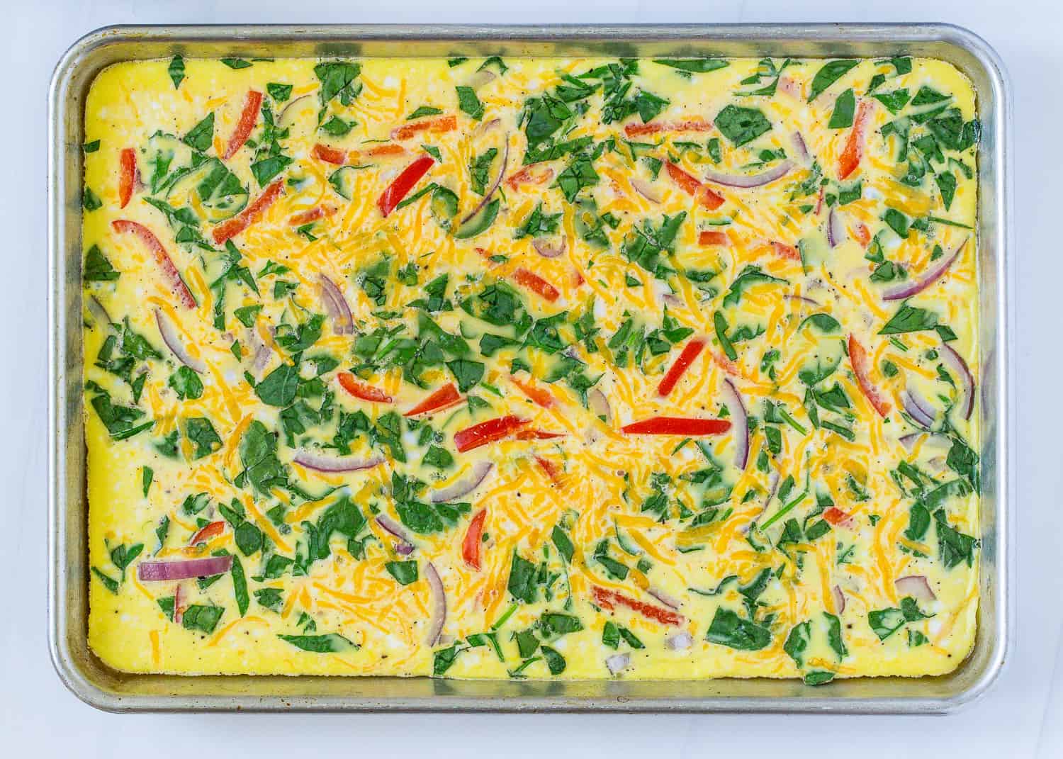 Baked scrambled eggs on a sheet pan, with vegetable add-ins.