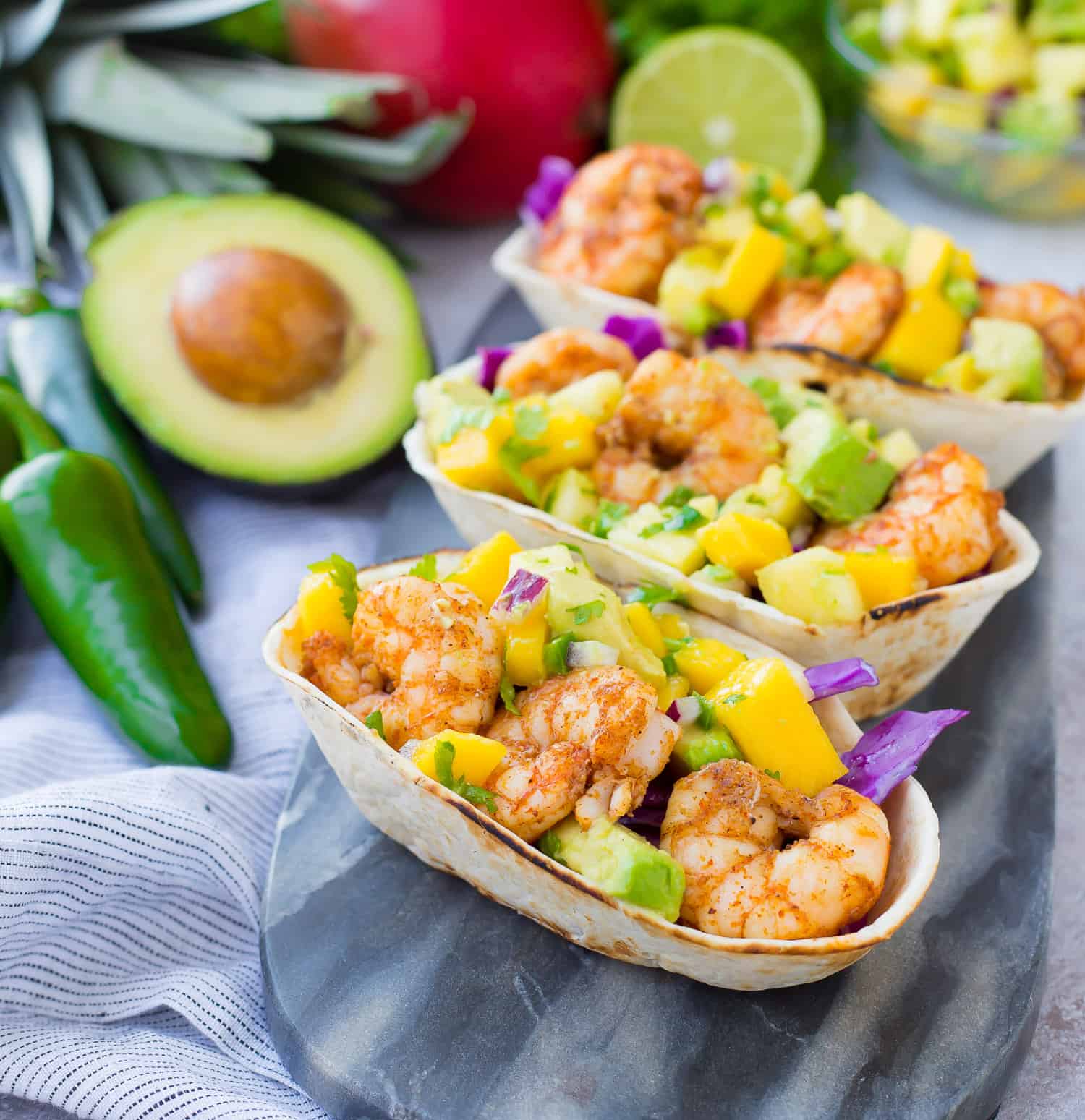 Shrimp tacos in tortilla boats, topped with mango and avocado salsa.