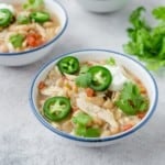 A serving of white chili in blue rimmed white bowl.