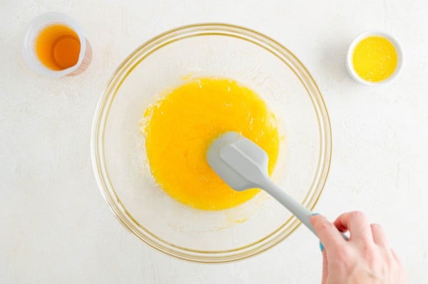 Wet ingredients are stirred together in a glass mixing bowl.