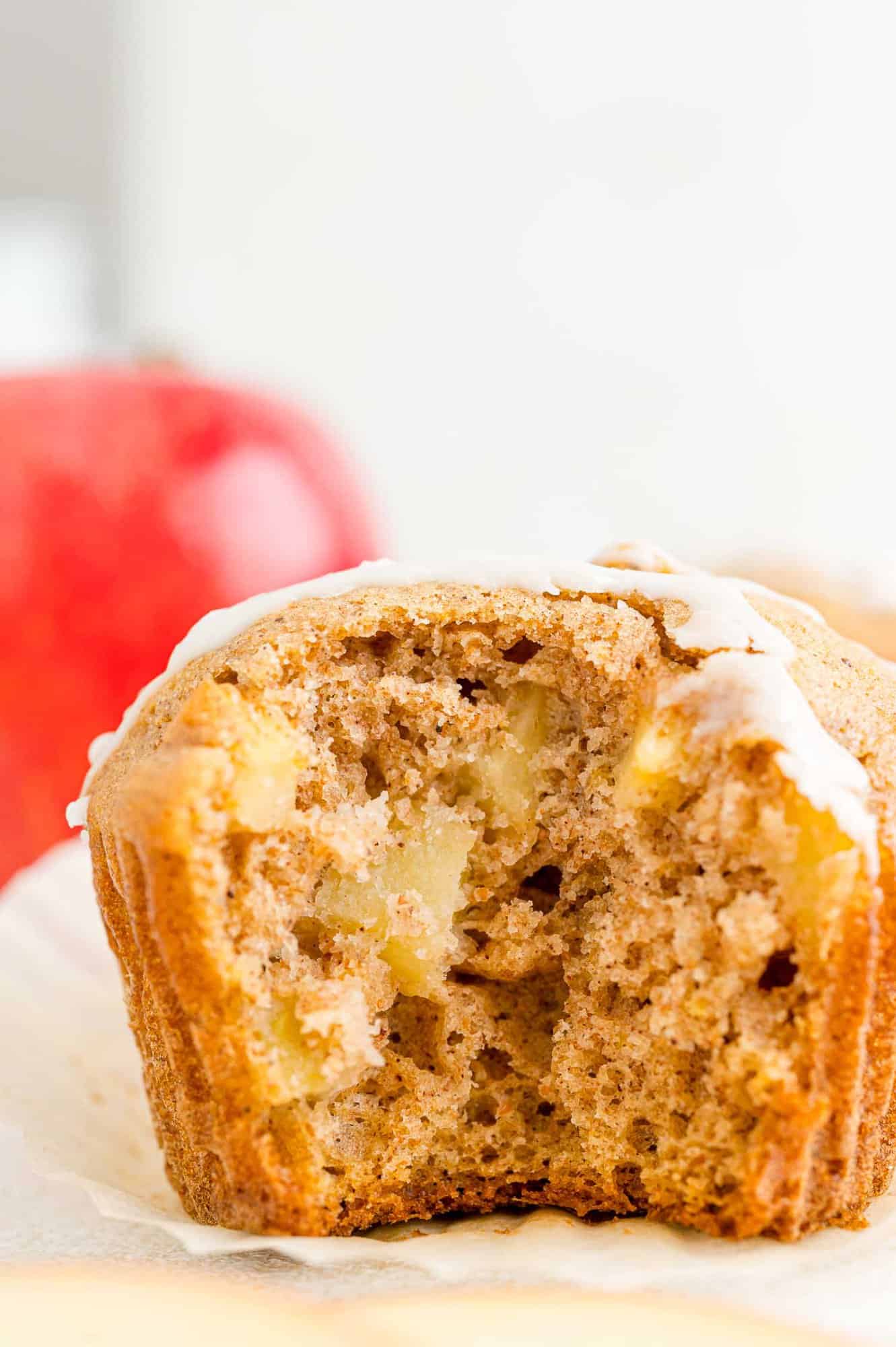 A glazed apple cider muffin with a bite missing.