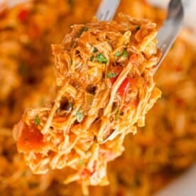 Crockpot salsa chicken, held between tongs.