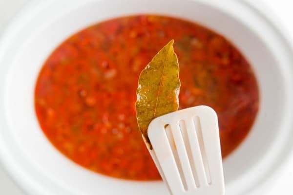 Bay leaf being removed from soup.