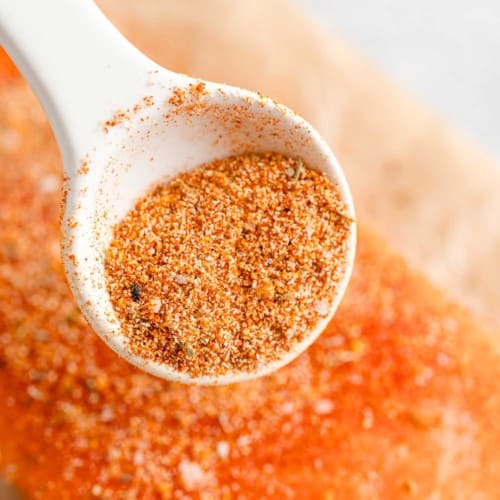 Salmon seasoning being sprinkled on salmon.