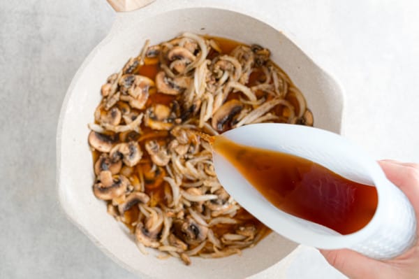 Broth added to a skillet with sauted mushrooms and onions.