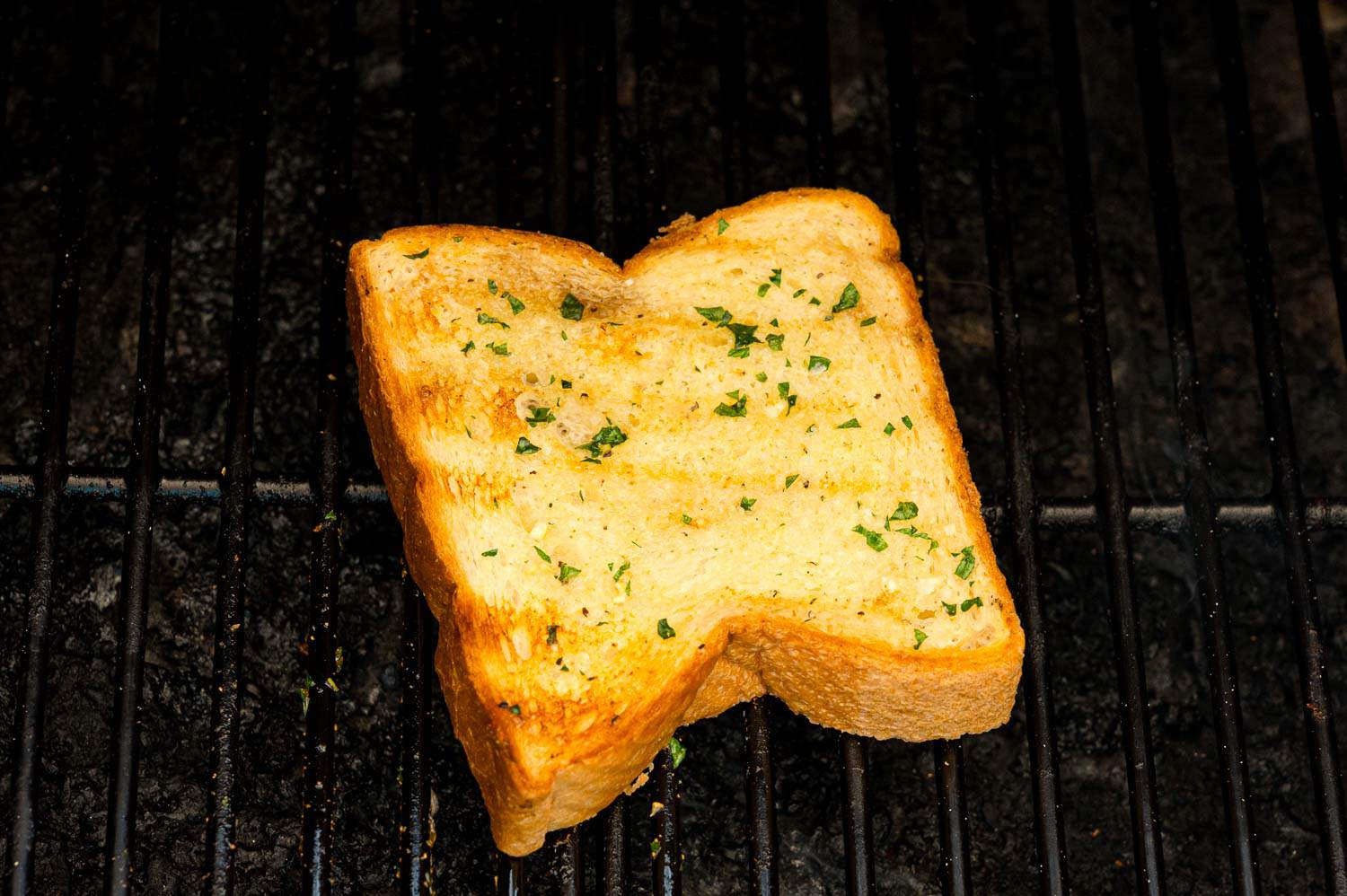 A slice of Texas toast garlic bread on a grill.