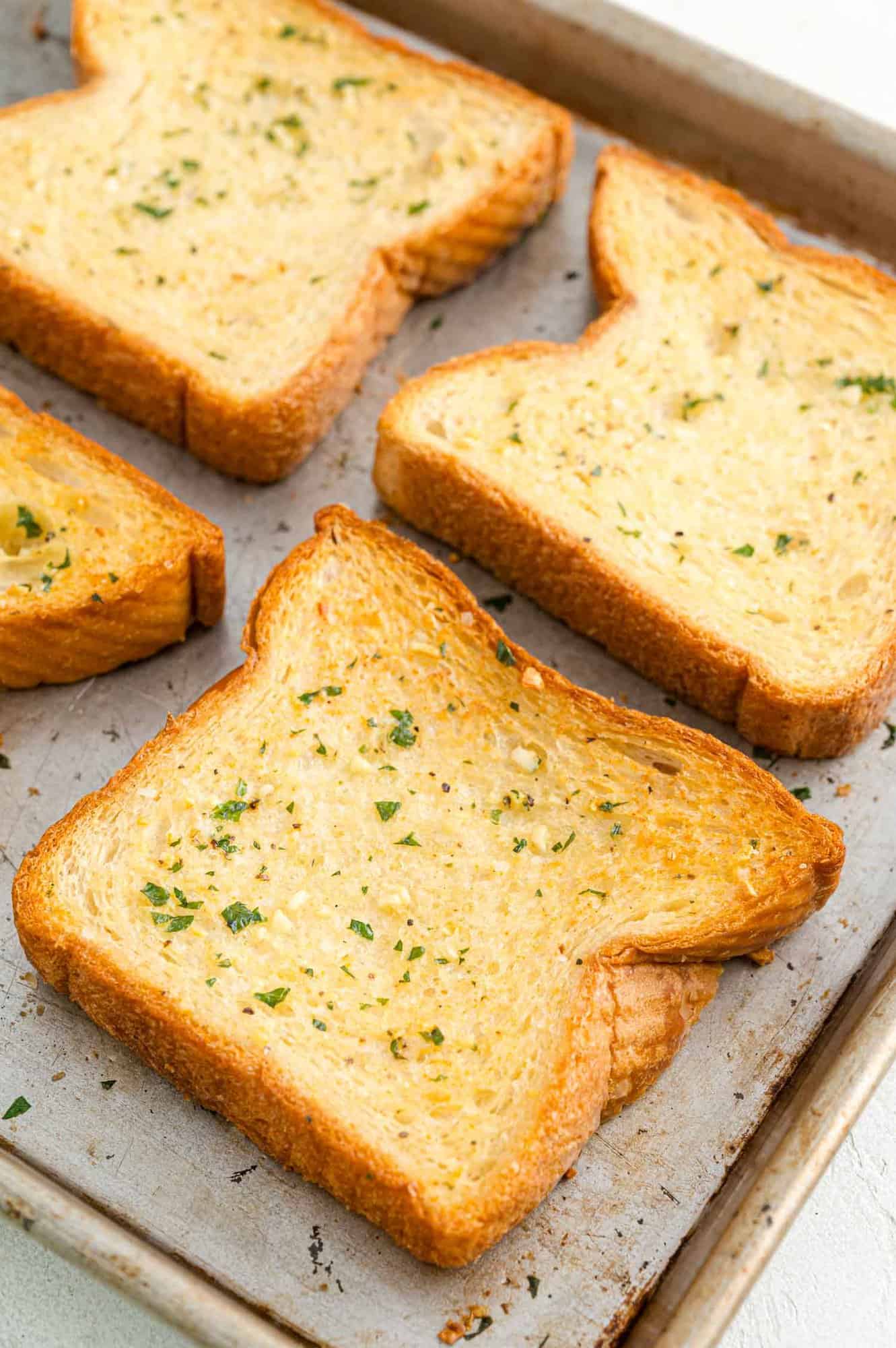 Close up of slices of Texas toast garlic bread on a baking sheet.