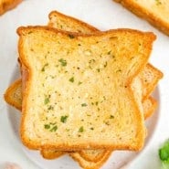 Overhead view of slices of Texas toast garlic bread on a white plate.