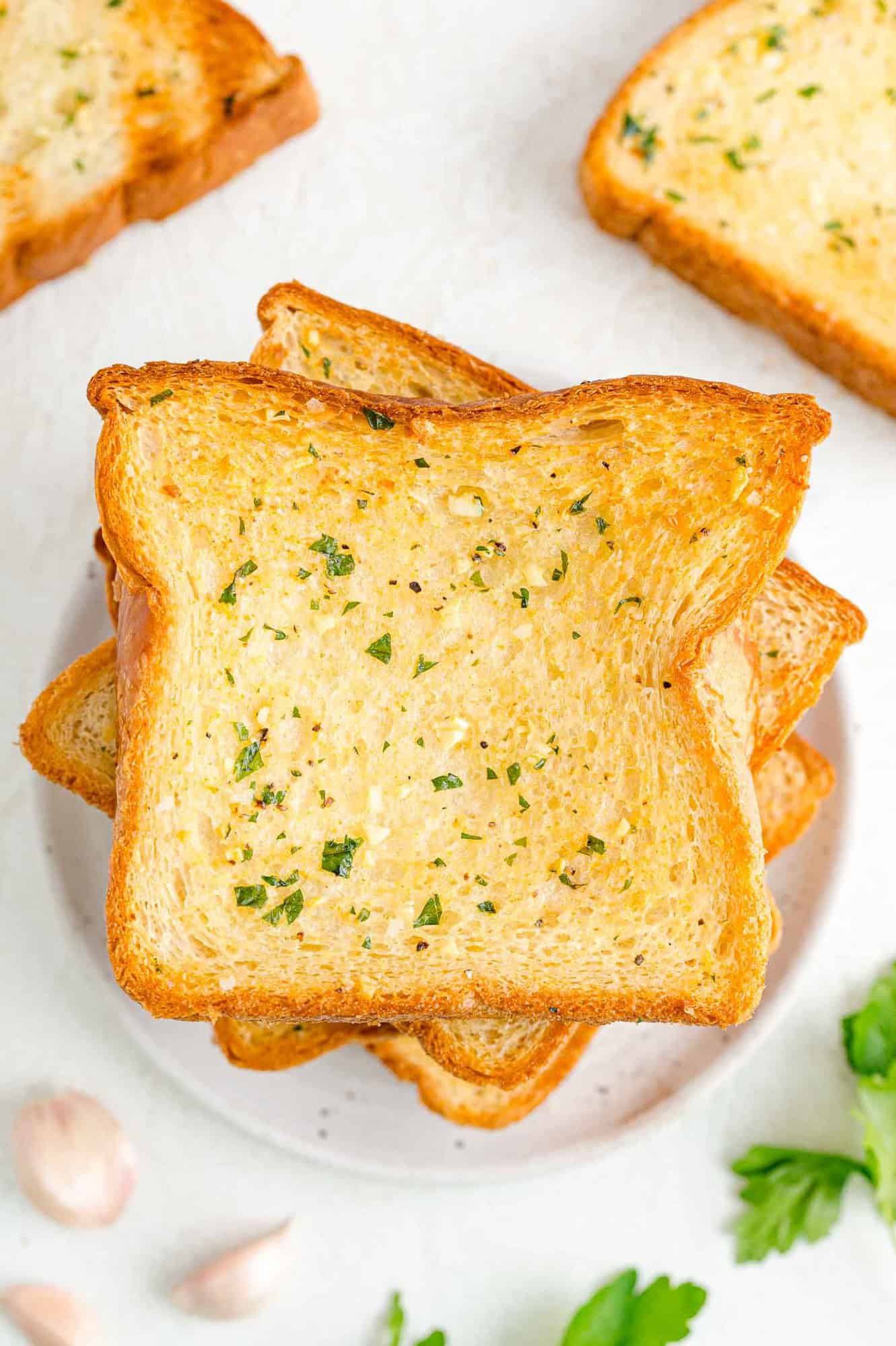 Overhead view of slices of Texas toast garlic bread on a white plate.