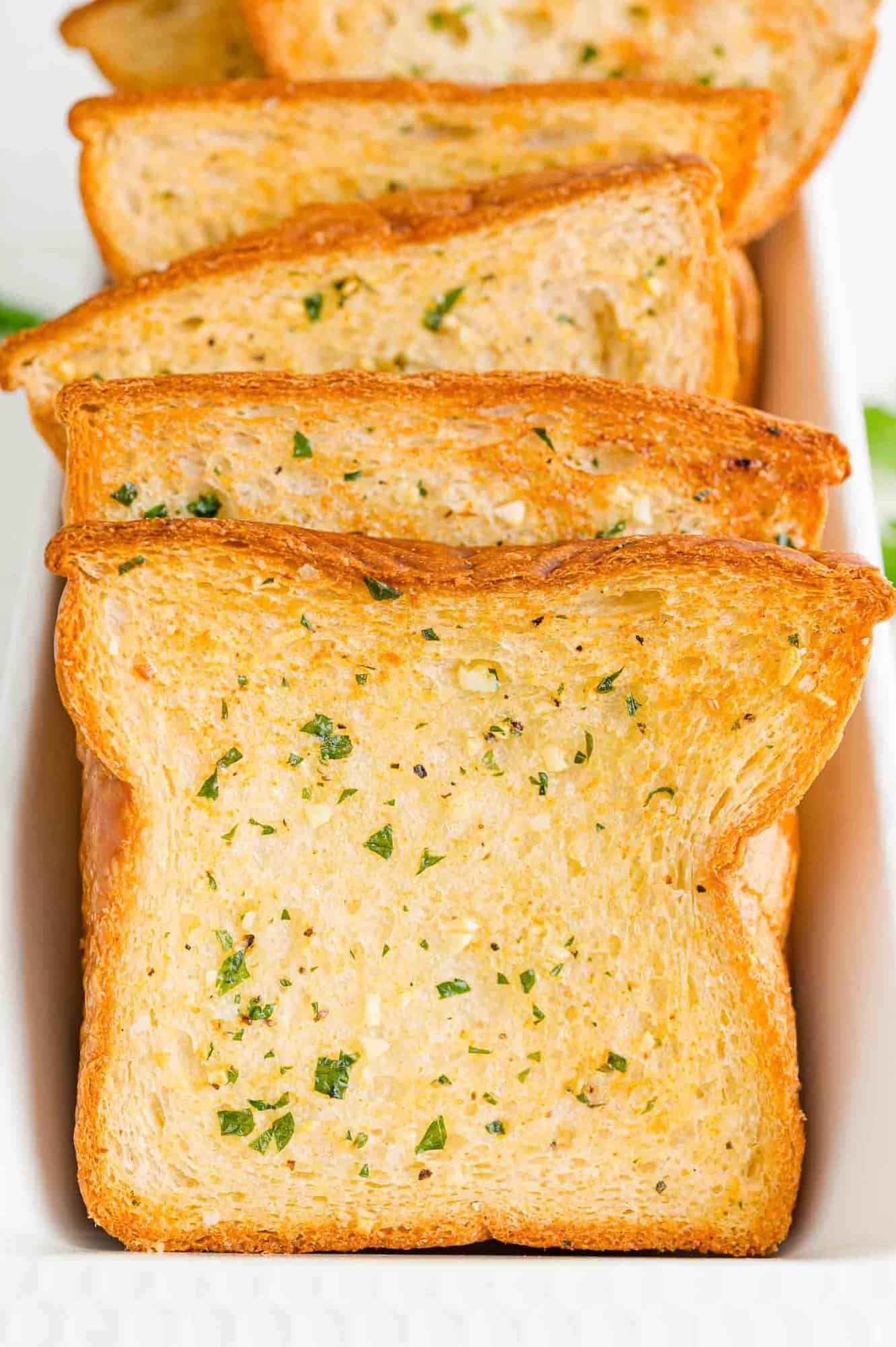 Slices of Texas toast garlic bread in a long rectangular serving tray.