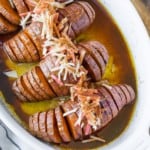Hasselback sweet potatoes in a white baking dish.