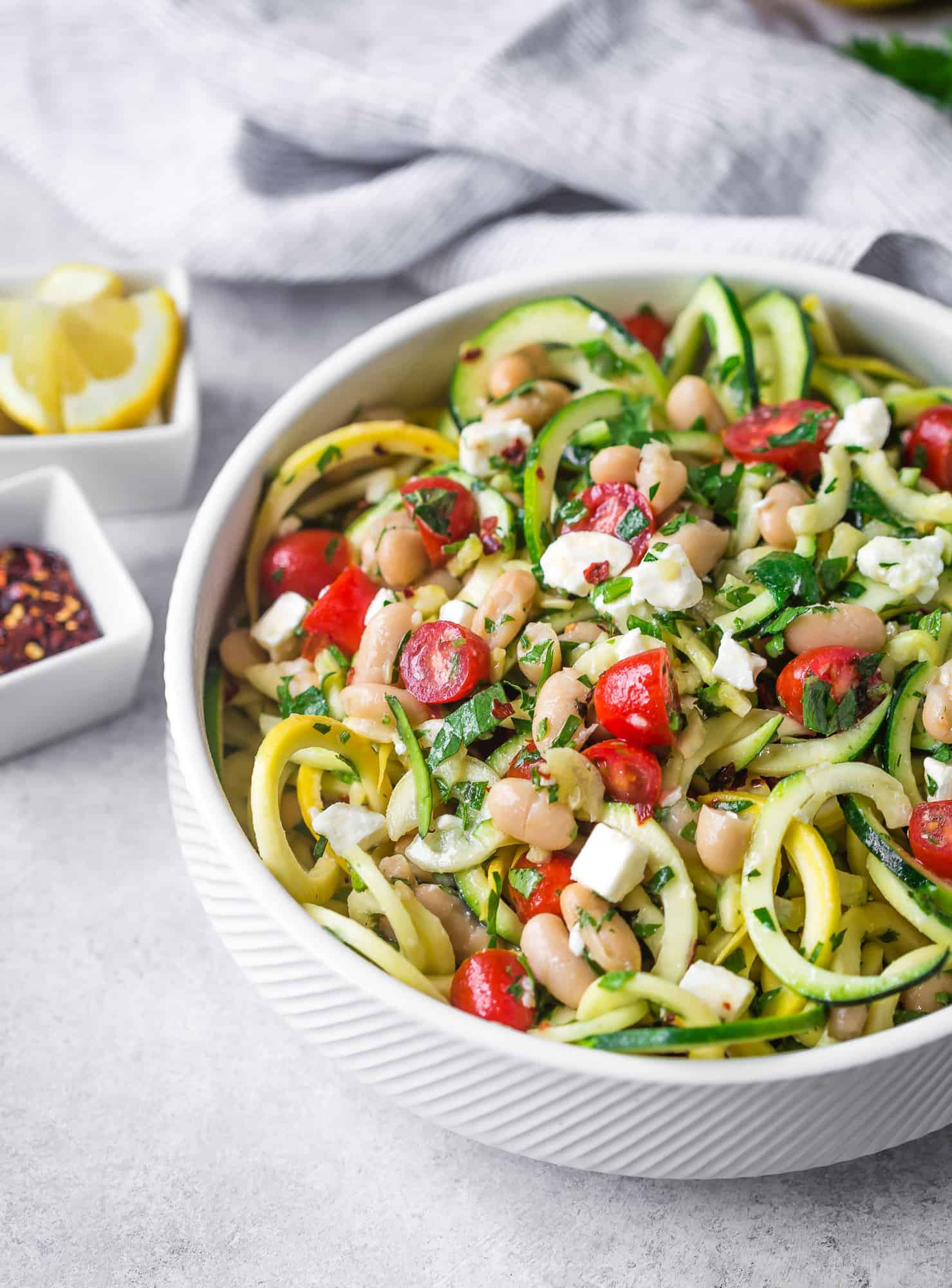 Zucchini noodle salad with fresh herbs, tomatoes, white beans.