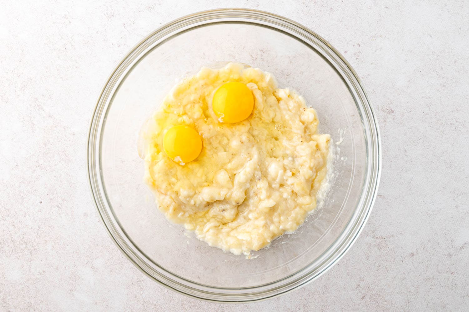 Eggs added to mashed bananas.