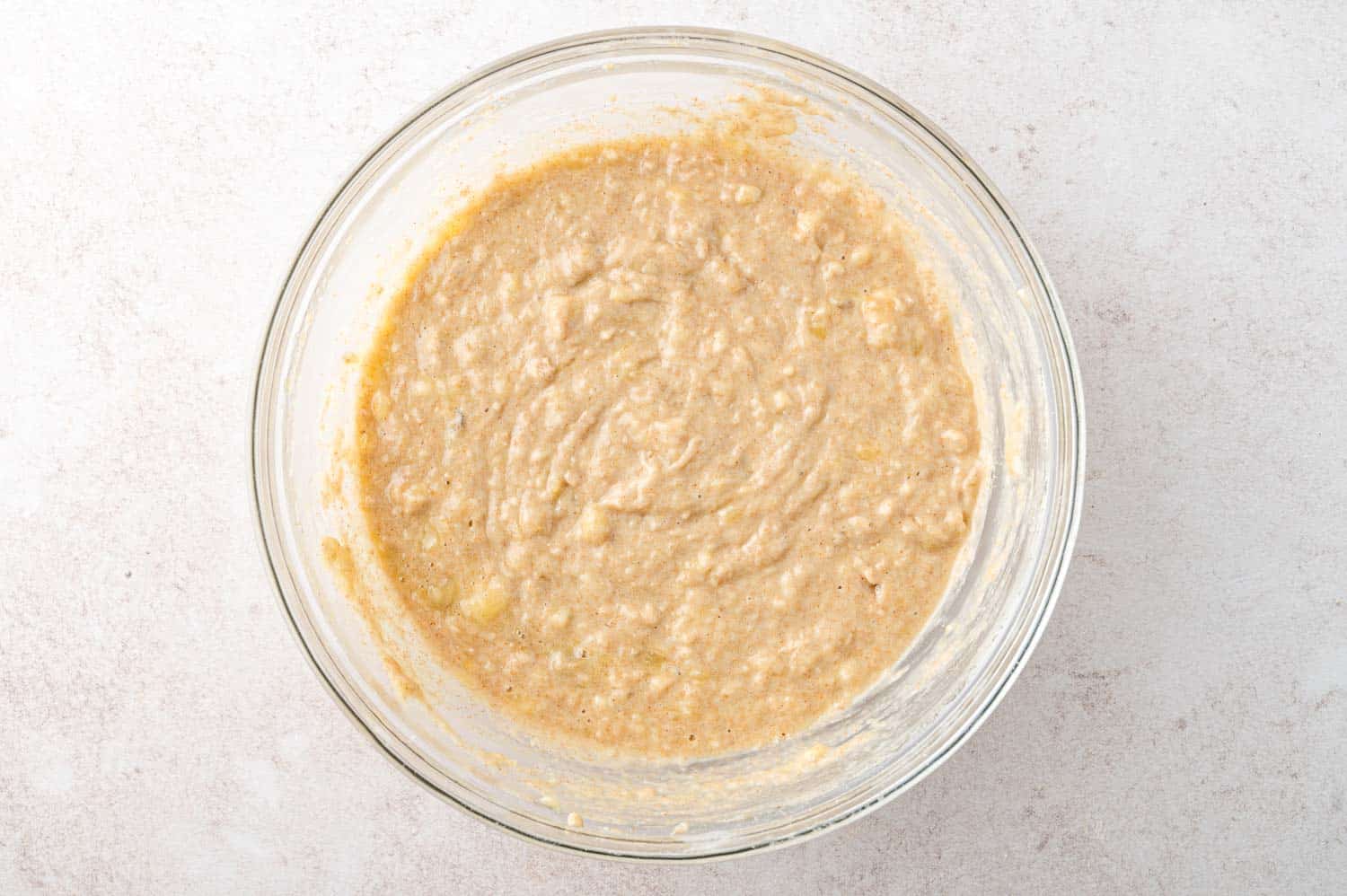 Muffin batter in a large glass mixing bowl.