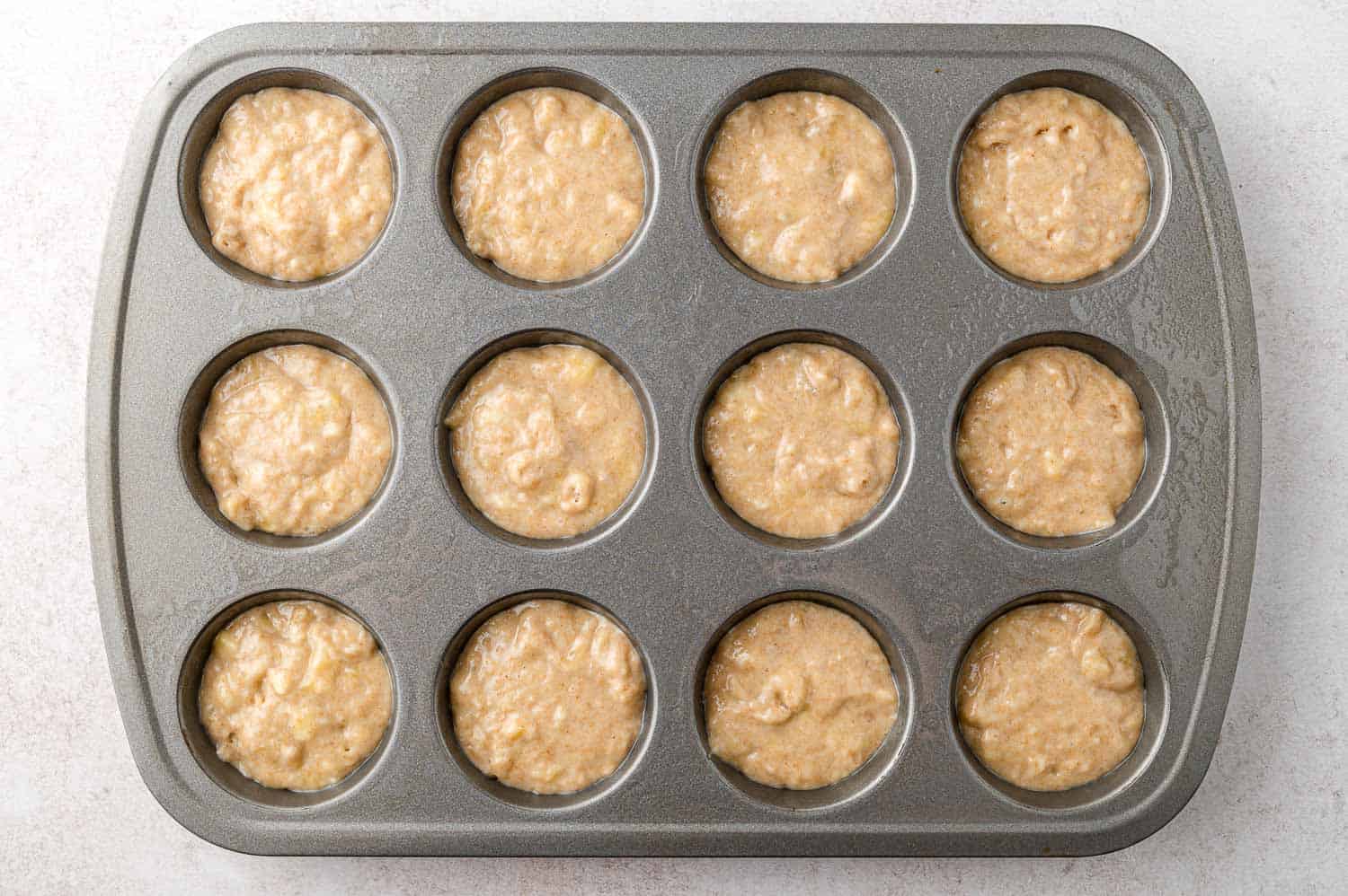 Unbaked muffins in muffin tin.