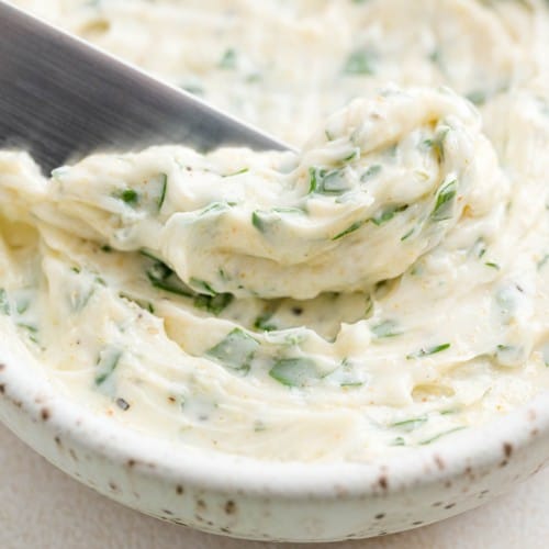 Garlic butter in a bowl and on a small knife.