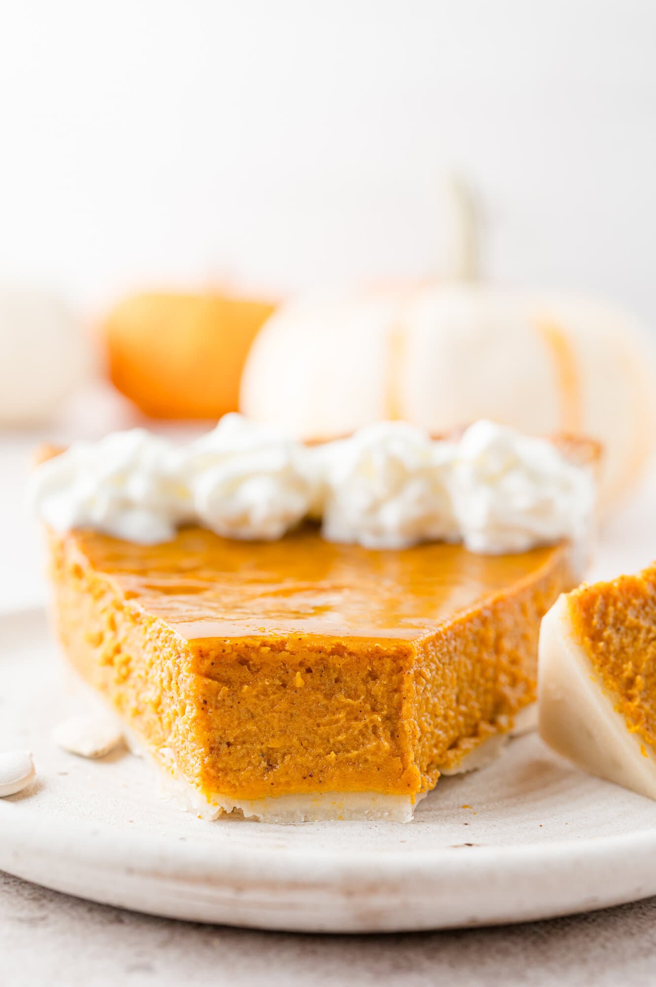Slice of pumpkin pie with a bite taken out of it.