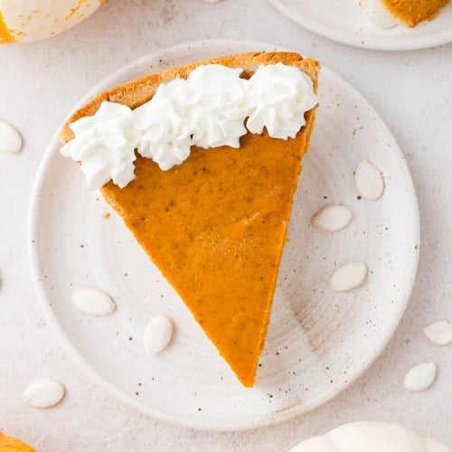 Slice of pumpkin pie, viewed from above, with whipped cream.
