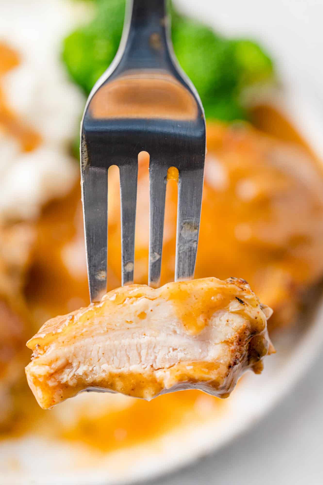Chicken thigh on fork, cut to show inside.