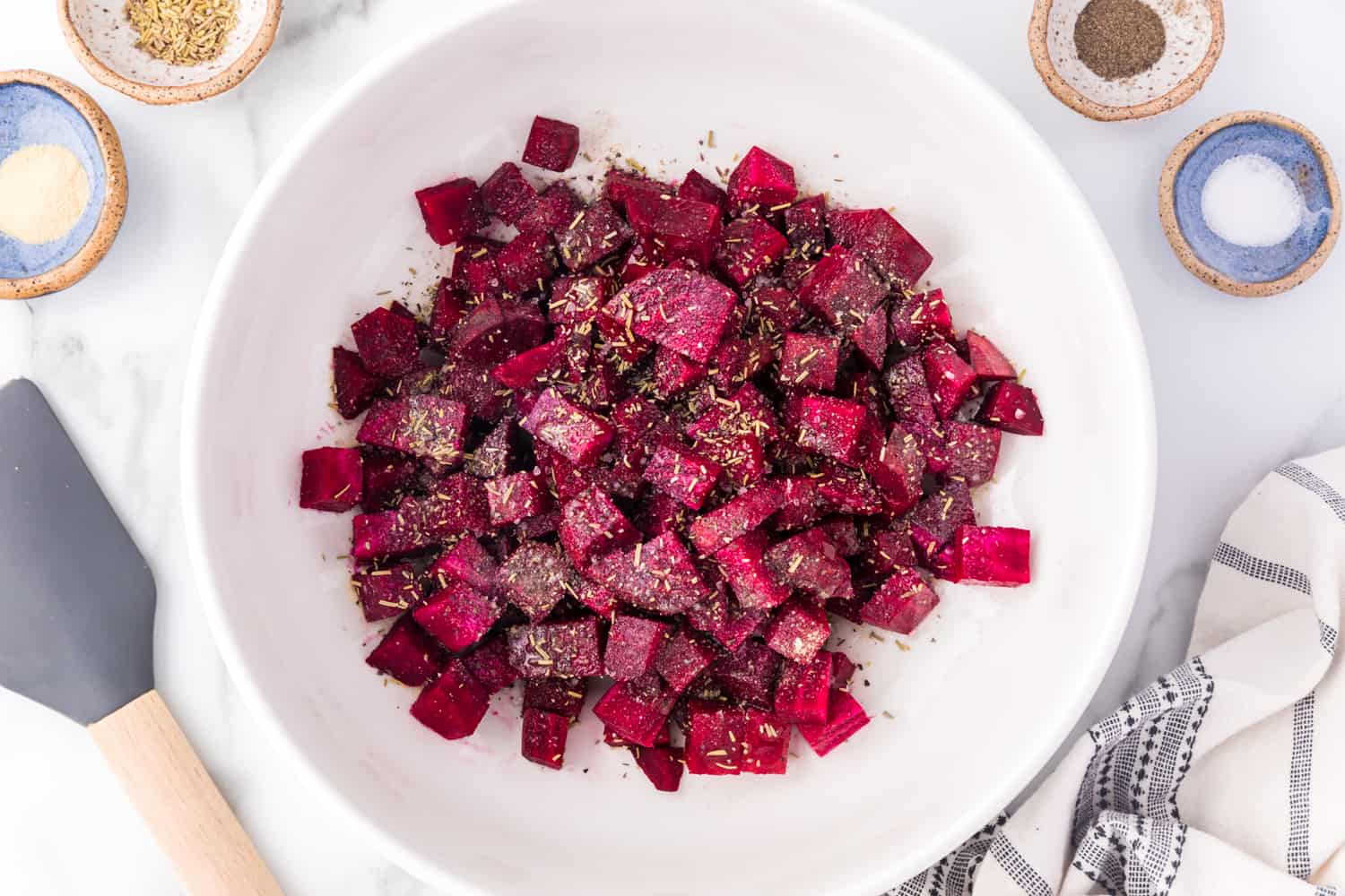 Cubed beets in a bowl, seasoned, but not yet cooked.