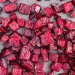 Roasted beets on a sheet pan, sprinkled with rosemary.