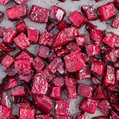 Roasted beets on a sheet pan, sprinkled with rosemary.