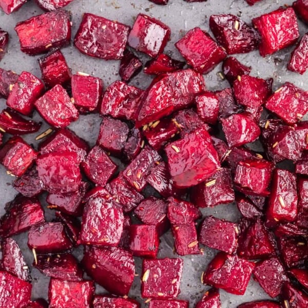 Roasted beets on a sheet pan, sprinkled with rosemary.