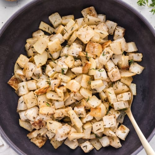 Roasted turnips in a large black bowl.