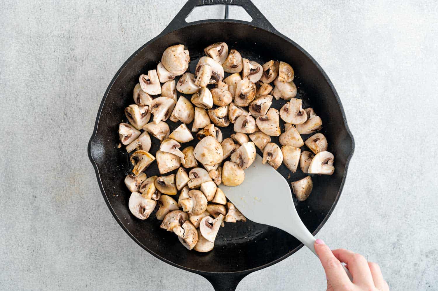 Uncooked mushrooms in a black pan.