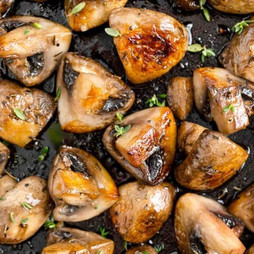 Sautéed mushrooms with marsala close up, sprinkled with herbs.