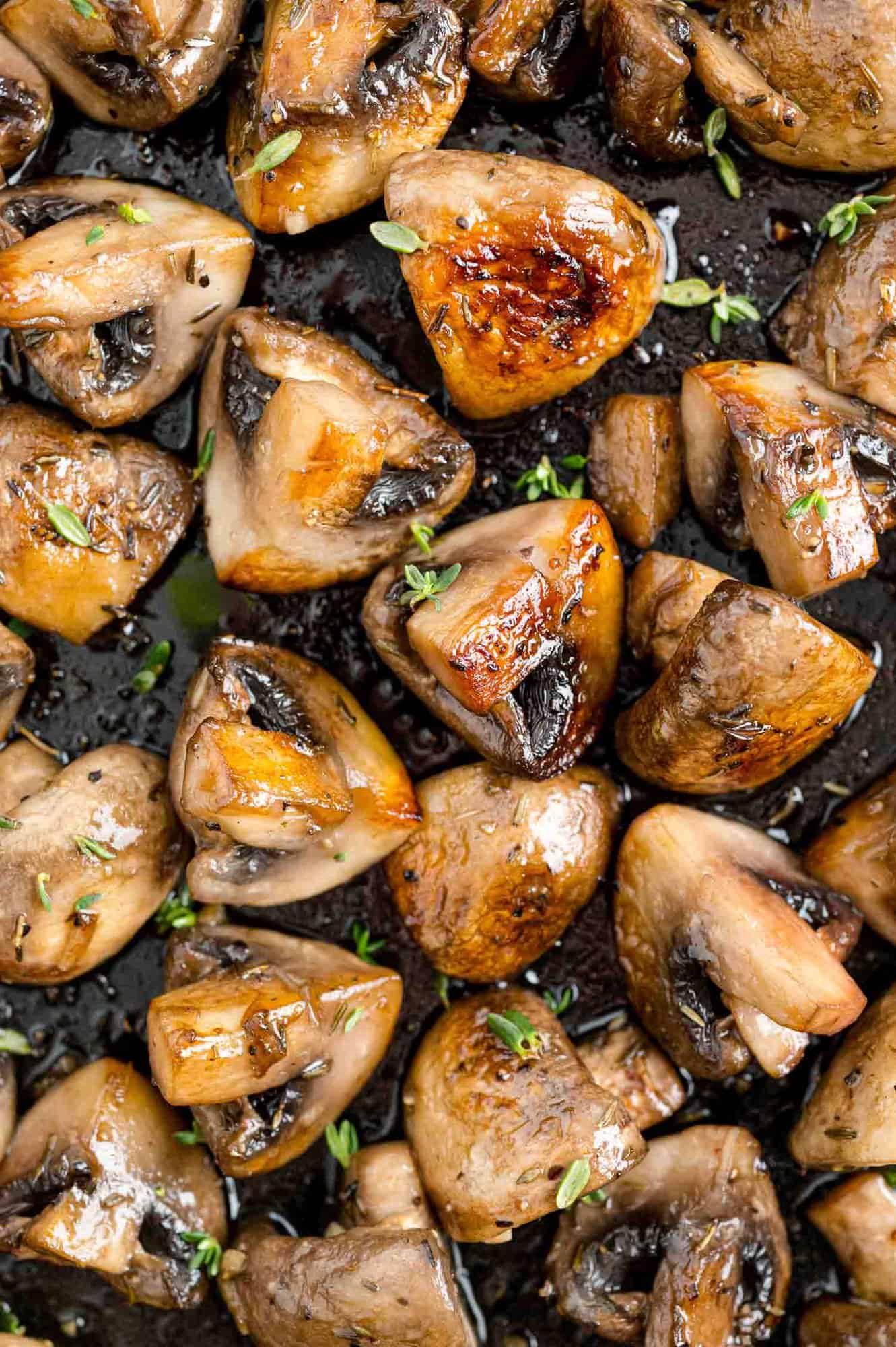 Sautéed mushrooms with marsala, filling the frame, sprinkled with herbs.