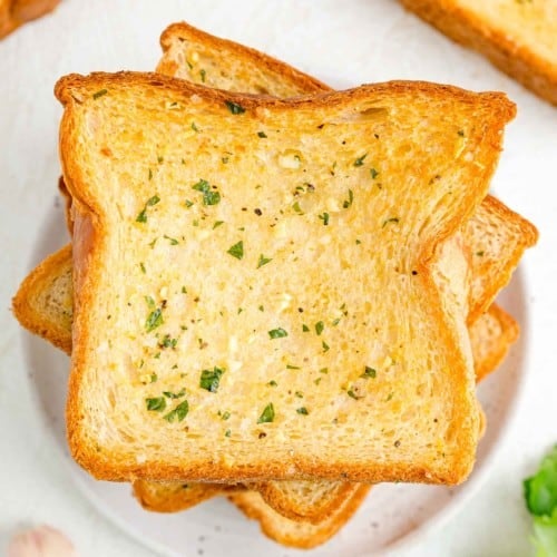 Overhead view of slices of Texas toast garlic bread on a white plate.