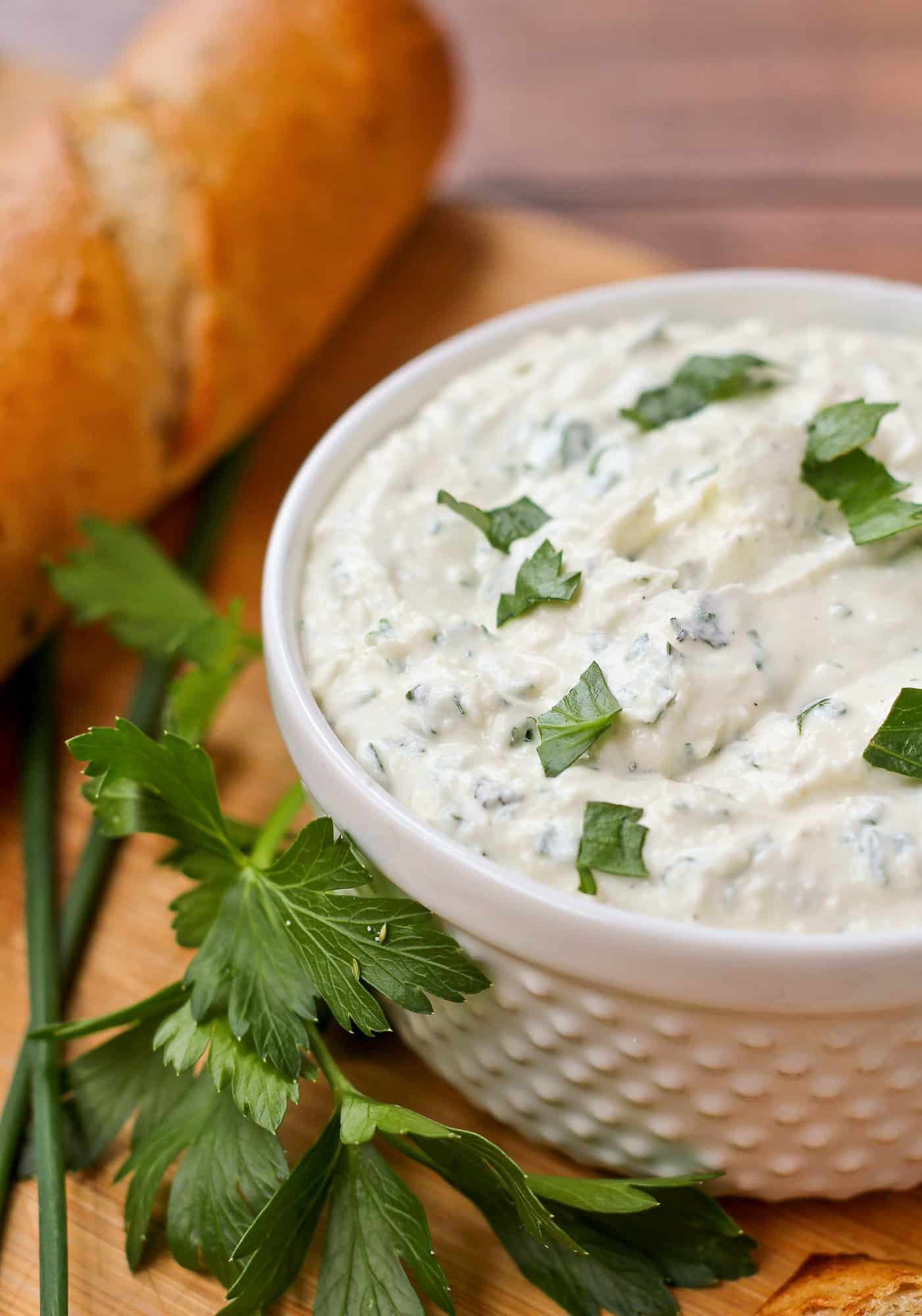 Feta dip with herbs in a small white bowl.