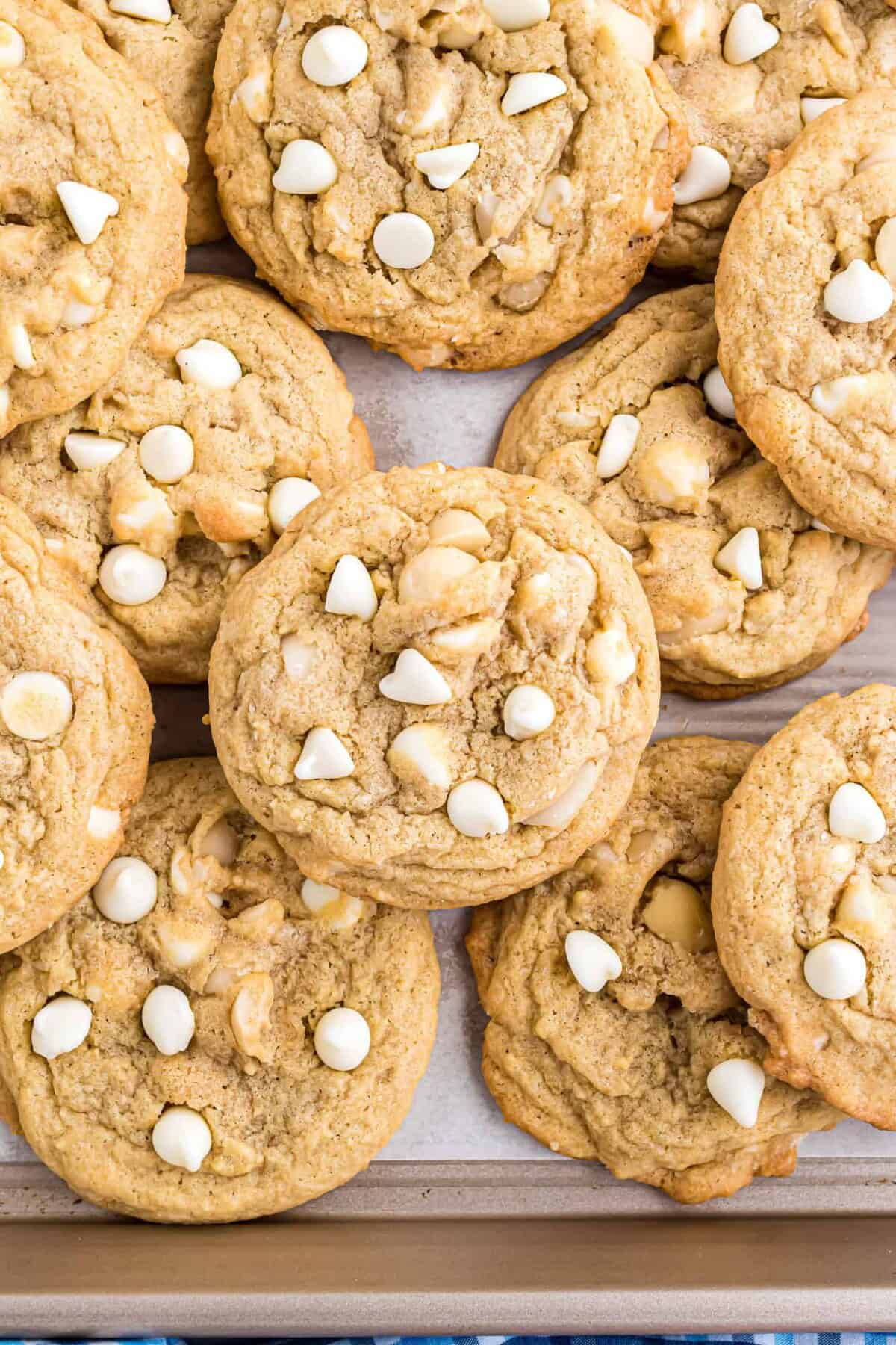 Overhead close up view of white chocolate macadamia nut cookies on a parchment-lined baking sheet.