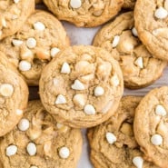 Overhead close up view of white chocolate macadamia nut cookies on a parchment-lined baking sheet.