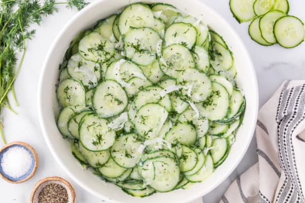 Cucumber salad in a white bowl.