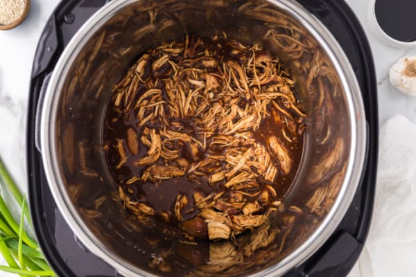 Shredded teriyaki chicken inside the instant pot.