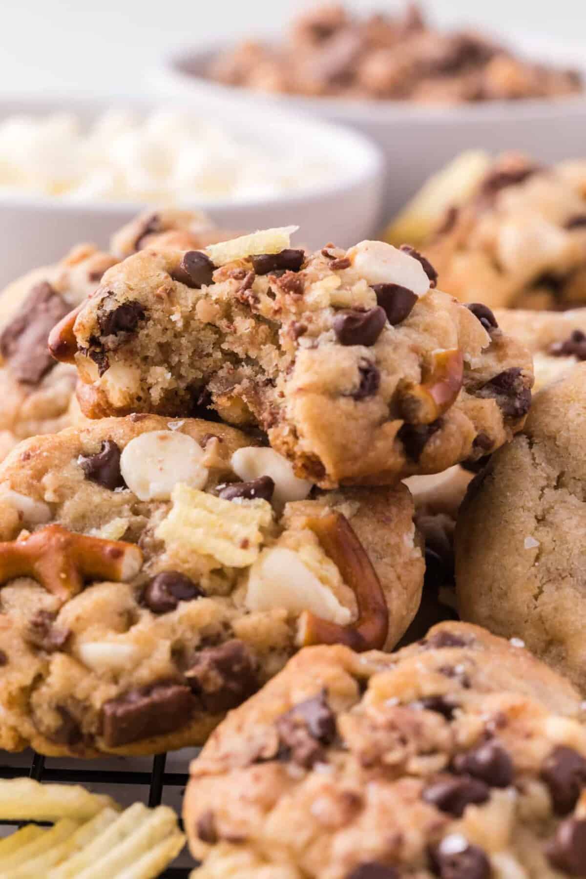 Close up of a pile of kitchen sink cookies with a bite missing from the top cookie.