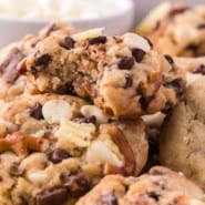 Close up of a pile of kitchen sink cookies with a bite missing from the top cookie.