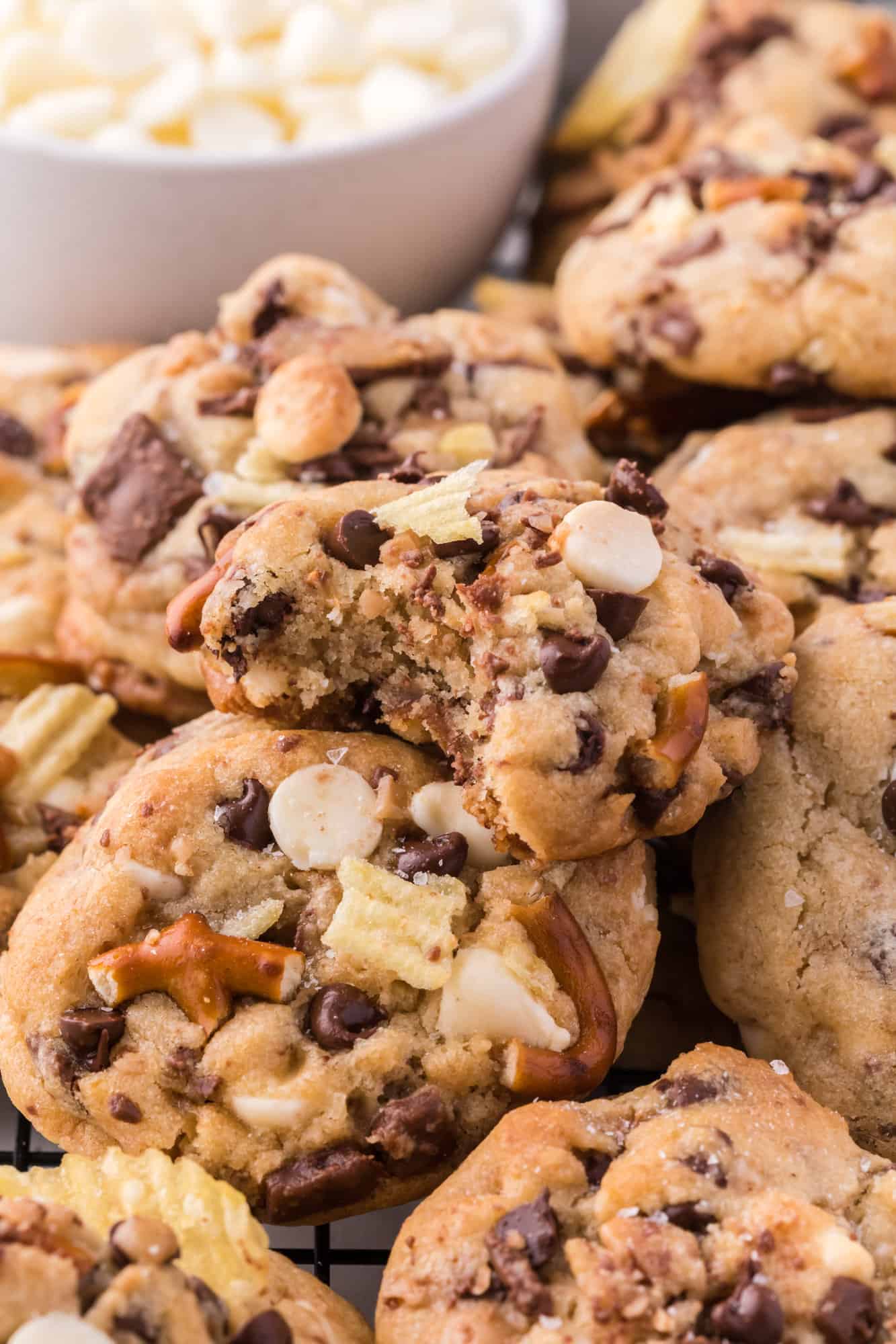 Close up of a pile of kitchen sink cookies with a bite missing from the top cookie.