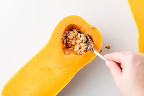 Seeds being scooped out of squash.