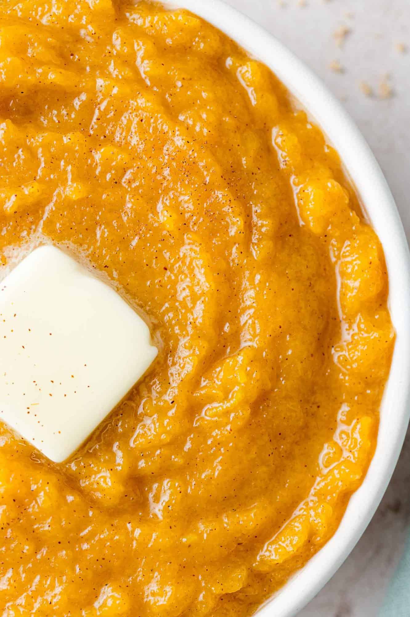 Butter melting on a bowl of mashed squash.
