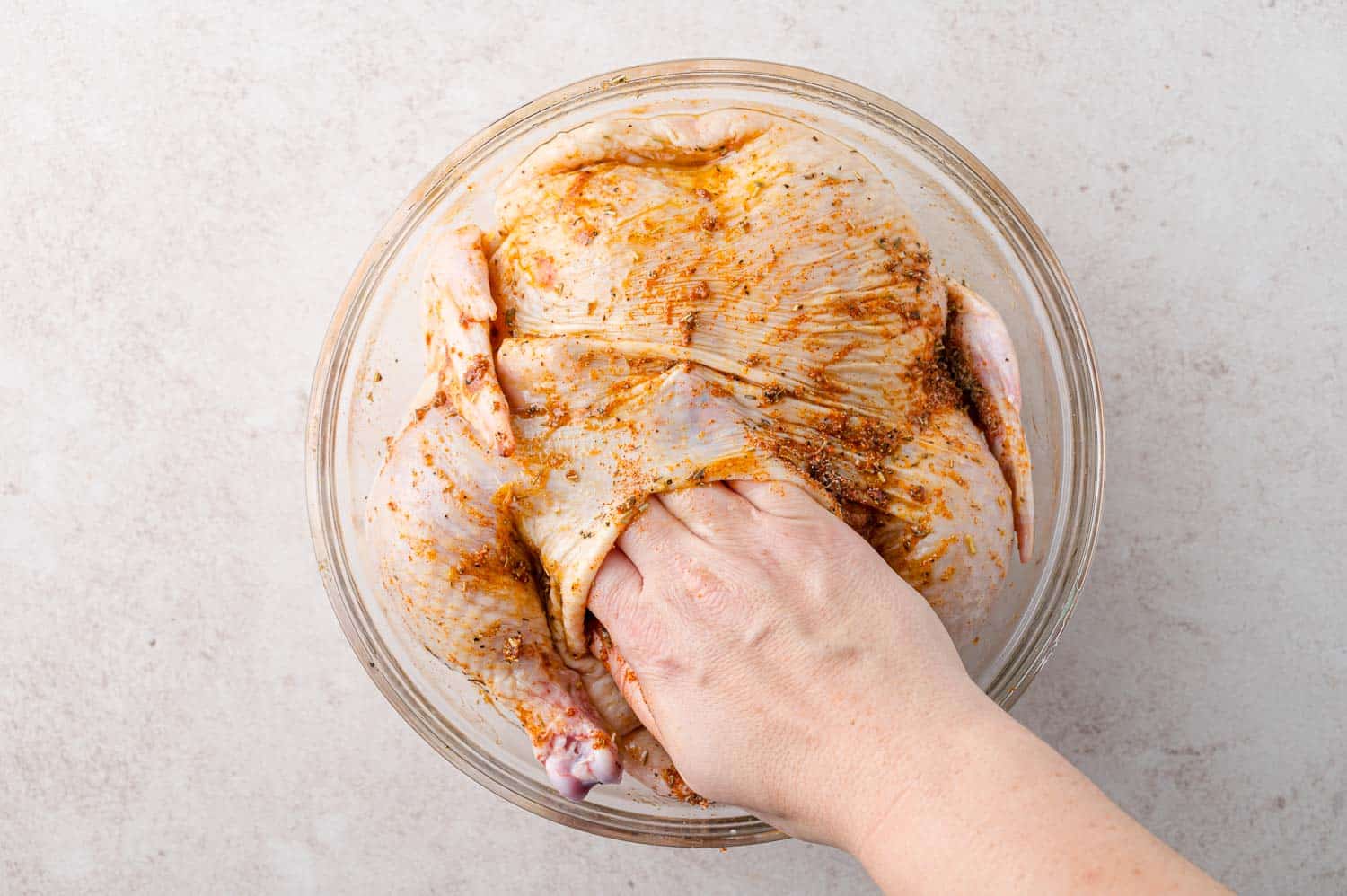 Spice rub being added under skin of chicken.