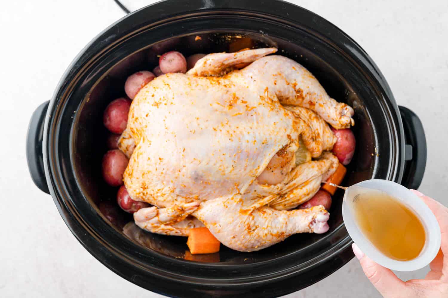 Broth being poured into slow cooker.