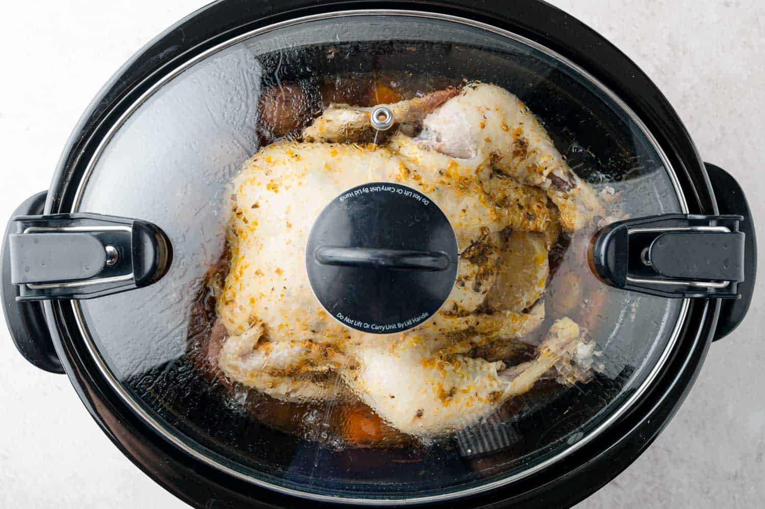Cover placed over chicken in slow cooker.